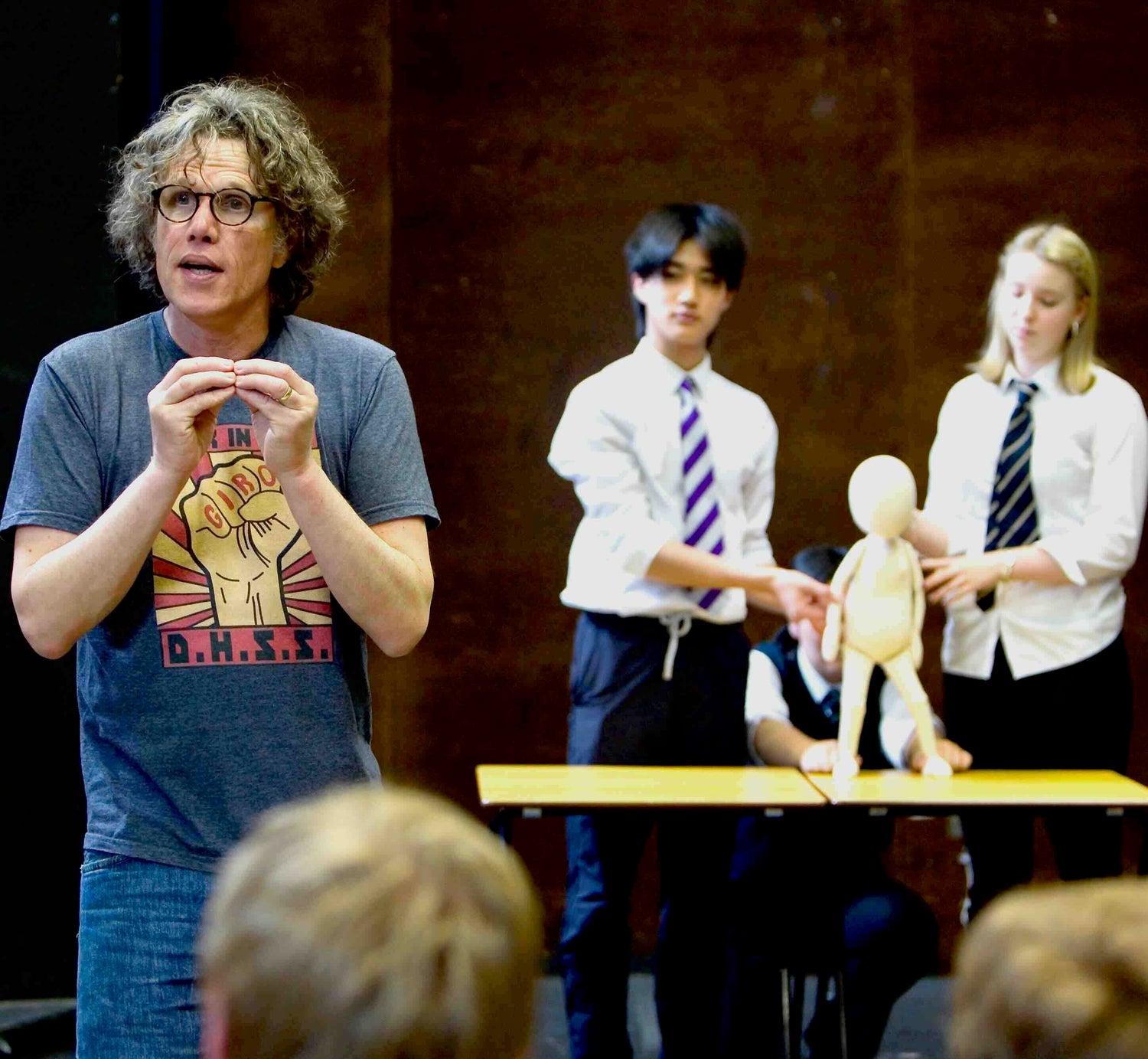 Teacher demonstrating with a puppet in front of students in a classroom setting