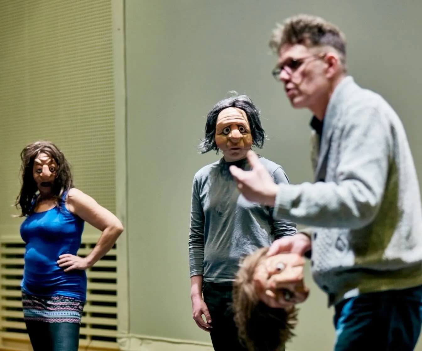 Two people wearing masks while a teacher explains.